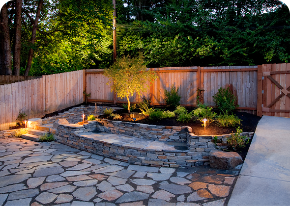 Backyard with illuminated stone landscaping